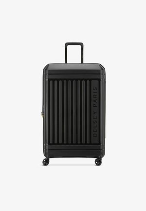 Maleta rígida negra con estrías verticales, equipada con un mango retráctil y cuatro ruedas para una fácil movilidad. Logo de "Delsey Paris" grabado.