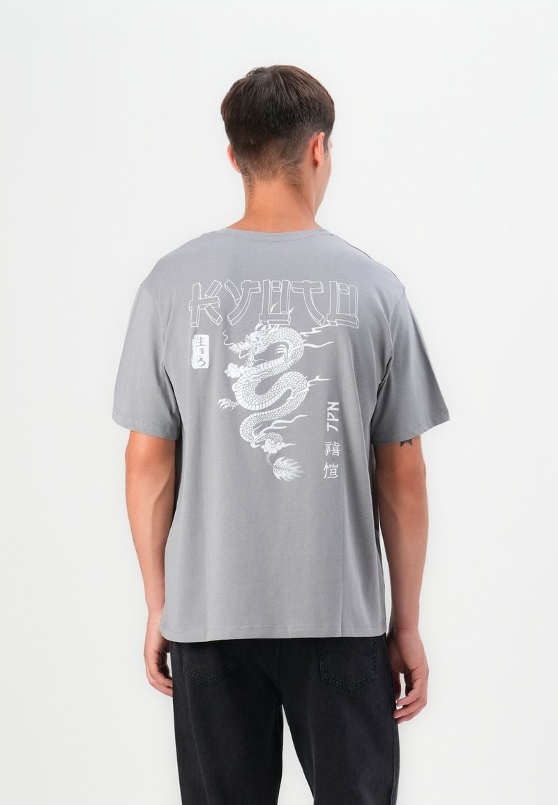 Grå kortærmet t-shirt med et dragegrafik på ryggen, der har hvid tekst og intrikate linjedetaljer, lavet af blødt bomuldsstof.