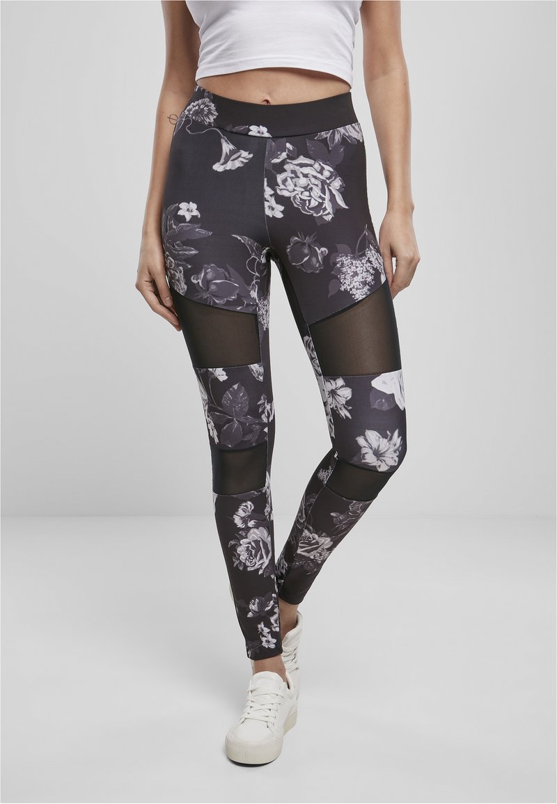 Svarta blommiga leggings med genomskinliga meshnätspaneler, som har en hög midja och en ankel-lång design. Tyget har en slät textur.