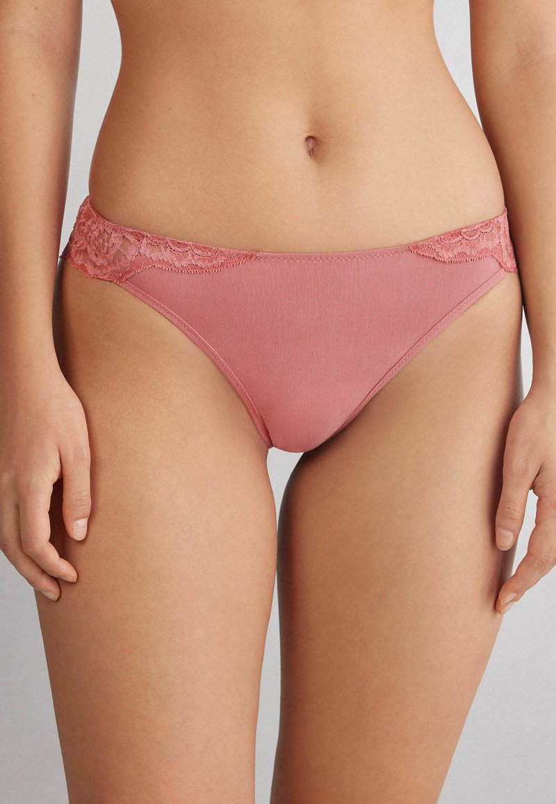 Katoenen bikini in zachtroze met kantafwerking bij de taille en voorkant. Klassieke snit met een gladde textuur en minimale detailing.