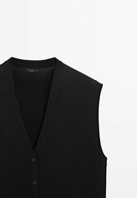 Schwarzer ärmelloser V-Ausschnitt-Pullover mit weicher Textur, ausgestattet mit einem Knopfverschluss und einem minimalistischen Design, gefertigt aus leichtem Strickmaterial.