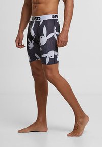 Boxer-briefs extensibles noirs avec un motif répété de logos de lapins blancs, ceinture élastique avec la marque "PSD", longueur mi-cuisse.