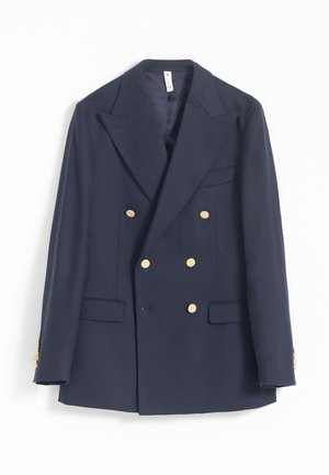Blazer azul marino de doble botonadura confeccionado en tejido suave, con botones dorados, solapas en pico y dos bolsillos frontales, mostrando un diseño entallado.