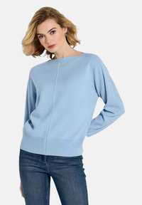 Helles blauer Strickpullover mit weitem Dekolleté, lockerer Passform und geripptem Saum. Verfügt über lange Ärmel und ein gespaltenes Design im Rücken.