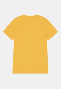 Żółta koszulka z krótkim rękawem, wykonana z bawełny, z okrągłym dekoltem i gładkimi brzegami, o gładkiej teksturze i jednolitym kolorze.