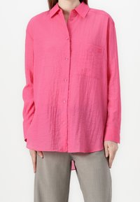 Knopf-up-Hemd in leuchtendem Pink, hergestellt aus leichtem Textilgewebe, mit Kragen, langen Ärmeln und einer Brusttasche.