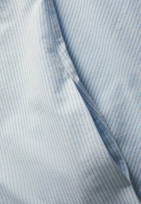 Tejido azul claro con rayas verticales blancas, que presenta una textura suave y un ligero brillo. El material parece blando y ligero.