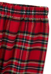 Rot kariertes Gewebe mit einem elastischen Bund, verziert mit Mustern in Schwarz, Grün, Weiß und Gelb. Weicher Stoff mit klassischem Design.