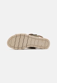 Brune lær sandale med justerbare stropper, tekstureret beige gummisål og bølgetmønster for bedre greb. Minimalistisk design.