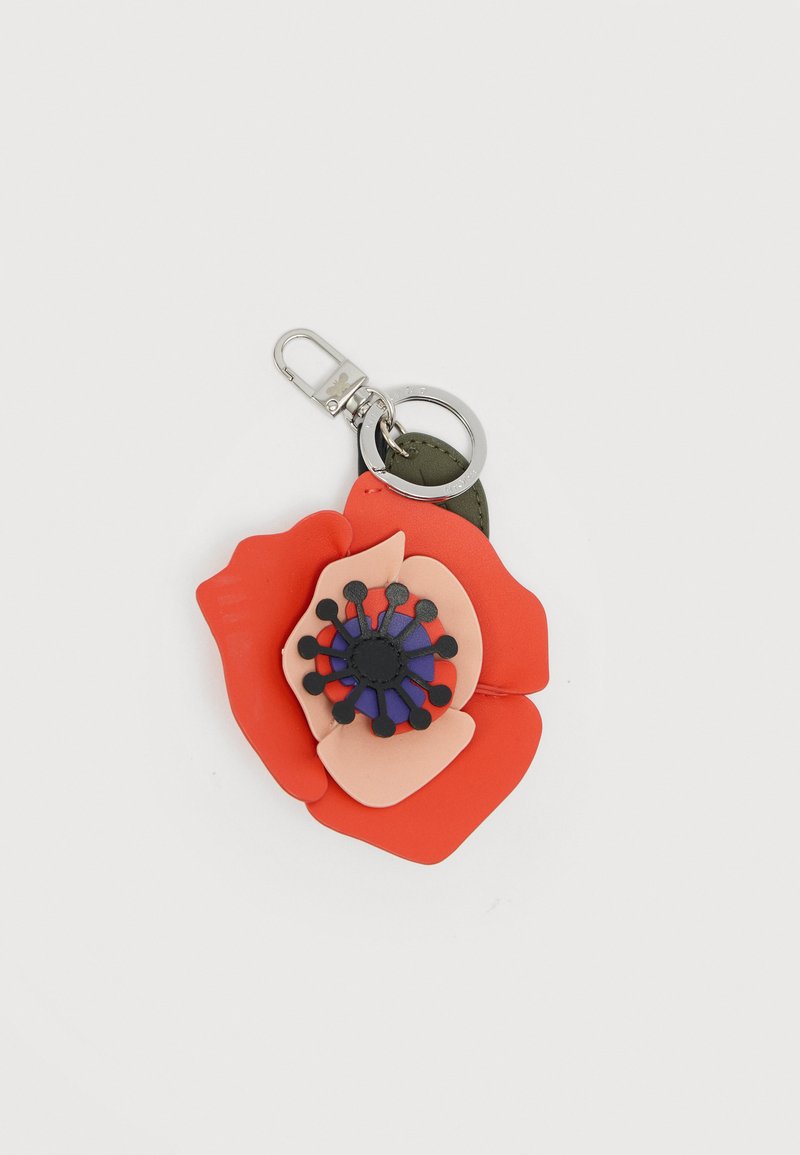 Porte-clés avec un motif floral en couches rouges et roses, centre noir et violet, fixé à un fermoir argenté et un anneau à clés sur fond blanc.