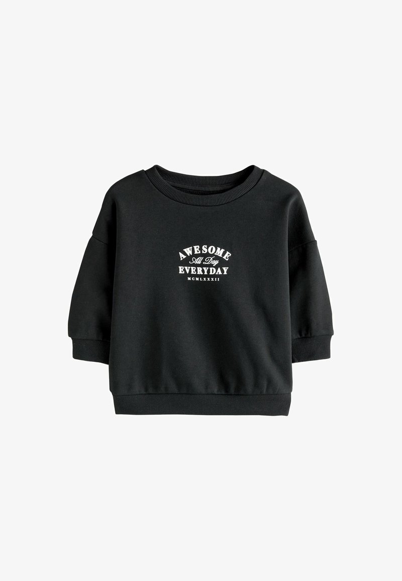 Sudadera negra con cuello redondo, costuras de hombros caídos y puños acanalados. Presenta un texto blanco que dice "ASOMBROSO TODO EL DÍA, CADA DÍA".