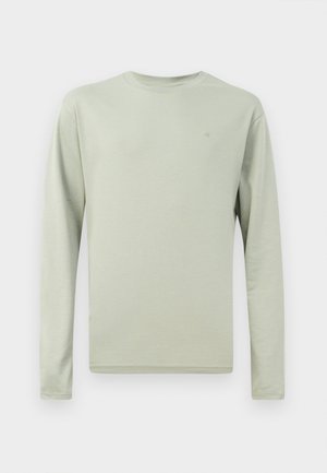 Long-sleeve shirt in light green fabric. Round neck, simple design with no patterns. Small logo on the chest. Soft, smooth texture.