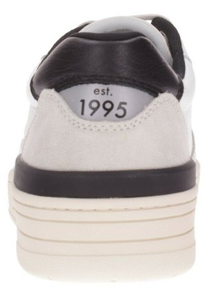 Zapatilla blanca con talón de gamuza gris y acentos de cuero negro. Presenta una suela blanca con ranuras horizontales y "est. 1995" impreso en el talón.