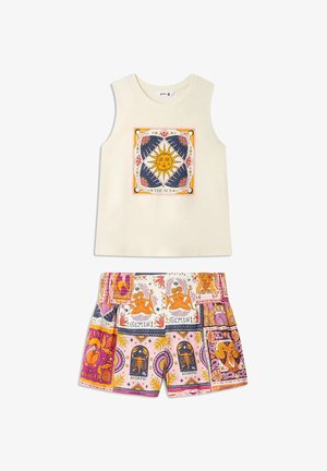 Haut sans manches crème avec un motif visage de soleil et un short à motifs multicolores de signes du zodiaque en tons rose, orange et bleu.