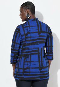 Blaue und schwarze abstrakt gemusterte Bluse mit dreiviertelärmeln, aus glattem Stoff gefertigt, mit einem subtilen Glanz und lockerer Passform.