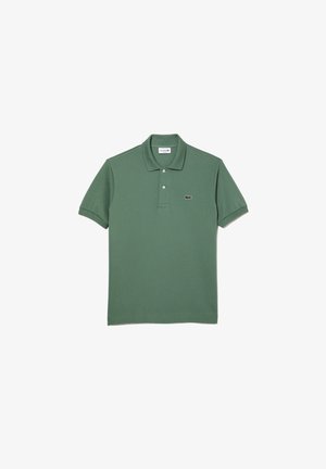 Polo vert en tissu texturé, avec un col, deux boutons et un petit logo brodé sur la poitrine.