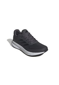 Scarpa sportiva nera con tomaia in rete, tre strisce iconiche sul lato, suola imbottita e suola esterna bianca a contrasto.