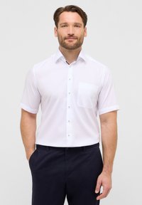 Witte shirt met korte mouwen en een button-down kraag, voorzien van een enkele borstzak en contrasterende knopen, gecombineerd met marineblauwe broek.