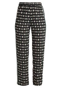 Mönstrade byxor med svart bas som har en geometrisk design i vitt, rött och beige. Elastisk midja och sidodetaljer.