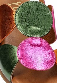 Sandalia de cuero con acentos circulares en tonos verde, rosa y marrón con un acabado texturizado, montada sobre una suela marrón clara.