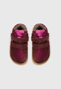 Chaussures pour enfants de couleur marron, avec une doublure intérieure en peluche, des panneaux en maille et deux sangles Velcro. Elles présentent une semelle en gomme et un design de bout arrondi.
