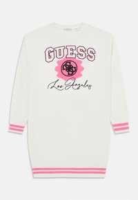 Vit stickad klänning med rosa ränder vid ärmsluten och nederkanten, med en framträdande "GUESS"-logotyp och "Los Angeles" broderat i svart.