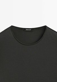 Sort T-shirt med korte ærmer lavet af blødt stof. Har en rund halsudskæring med en glat tekstur og et lille mærke indeni.