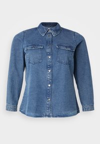 Denim shirt featuring a classic collar, two chest pockets, and a button-down front. The fabric is a medium blue with a smooth texture.