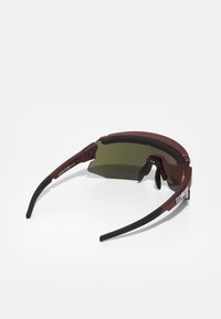 Ochelari de soare pliabili cu lentile verzi închise, ramă bordeaux și accente din cauciuc negru pentru confort. Prezintă un design elegant și tample ajustabile.