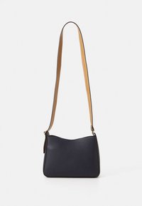 Tamsiai mėlynos odos pečių krepšys su lygiu paviršiumi ir lenktos formos. Turi šviesiai rudos reguliuojamą diržą ir minimalistinį dizainą.