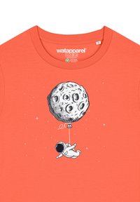Korallefarbenes Baumwoll-T-Shirt mit einem gedruckten Design eines Astronauten und des Mondes an einer Schnur, mit verstreuten Sternen im Hintergrund.