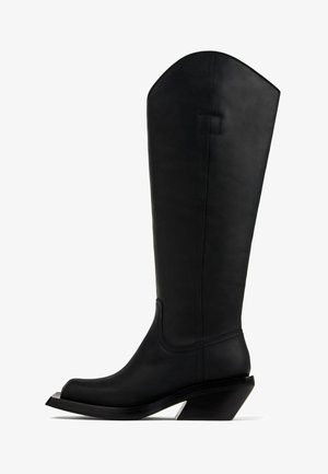 Hoge zwarte leren cowboylaars met schuine hak en minimale stikseldetails, zijaanzicht op witte achtergrond.