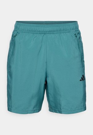 Teal sportshorts met een elastische tailleband, ritszakken aan de zijkanten en een zwart logo op de linker onderzijde. Glad, lichtgewicht materiaal.