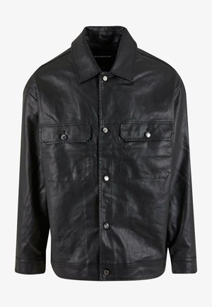 Schwarze Lederjacke mit einer knöpfbaren Front, zwei Brusttaschen und einem spitzen Kragen, die eine glatte Textur und ein minimales Design aufweist.
