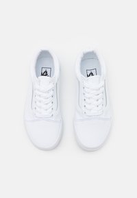 Hvide kanvas sneakers med lavt design. Funktioner inkluderer rund tå, seks snørehuller og et sort logo tags på tungen. Gummisål.