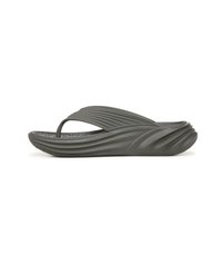 Grijze rubberen flip-flop met een gebogen, golvende zool; gestructureerde binnenzool; en een minimalistisch tussenstuk ontwerp.