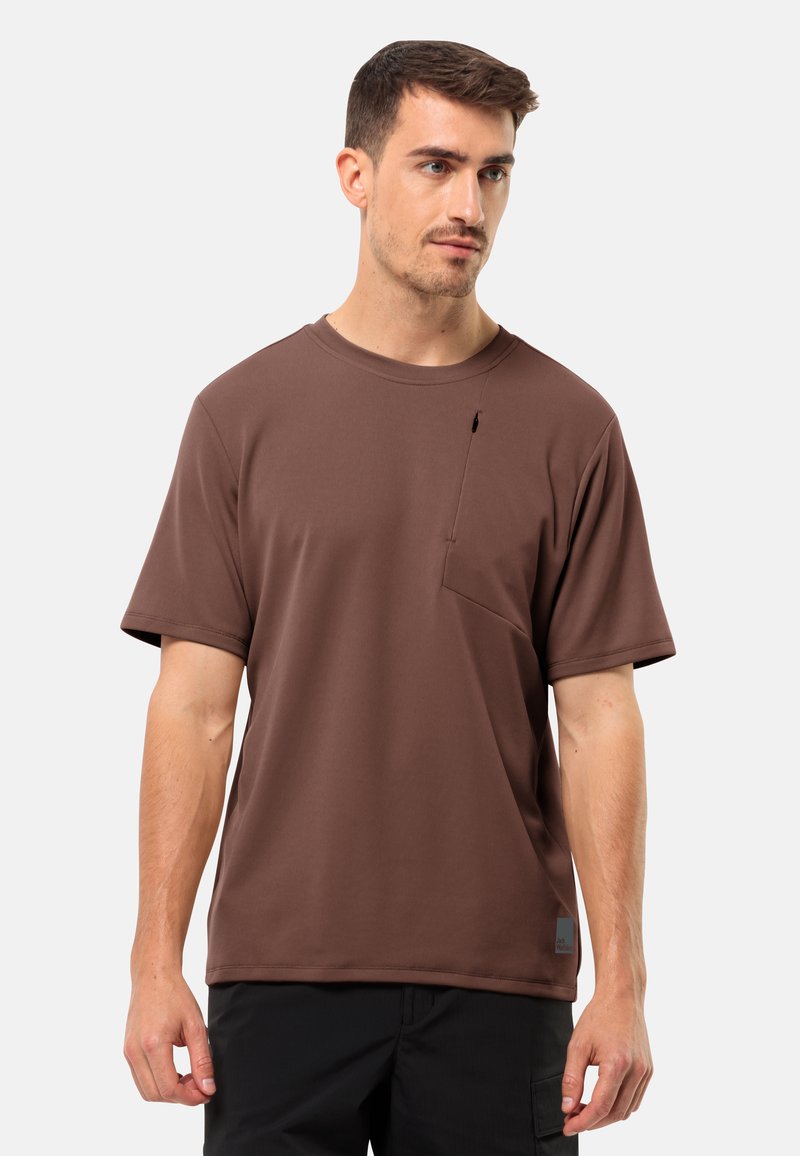 Brun kortærmet t-shirt med rund halsudskæring, der har en brystlomme og en lille metalaccent. Fremstillet af et glat, struktureret stof.
