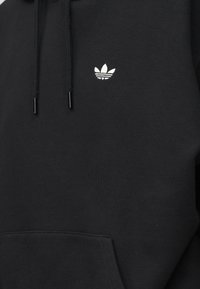 Sweat à capuche noir avec poche avant et cordons ajustables, avec un petit logo Adidas trefoil blanc sur la poitrine.
