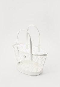 Borsa tote bianca con un design in rete di plastica e manici in pelle liscia. Presenta una forma ovale strutturata e una base piatta.