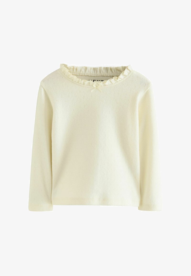 T-shirt bébé à manches longues crème avec tissu texturé, col à volants et petit nœud au niveau de l'encolure.