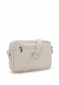 Liten ljusrosa crossbody-väska med justerbar rem, framficka med dragkedja och strukturerad ytfinish.