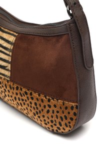 Brązowa skórzana torba z sekcjami ciemno brązowego zamszu, w wzory zwierzęce i zebry. Posiada gładką teksturę i zamek błyskawiczny.