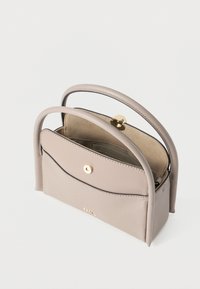 Lille beige læderhåndtaske med to runde håndtag, en frontlomme med en guldknaplås og et åbent hovedrum.