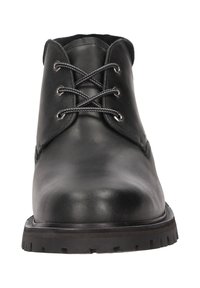 Stivale chukka in pelle nera con punta arrotondata, design con sei occhielli per i lacci e suola in gomma testurizzata per una buona trazione. Presenta dettagli di cucitura minimi.