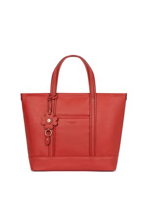 Sac cabas en cuir rouge avec deux poignées, une poche avant et un porte-clés en forme de fleur suspendu à une poignée.