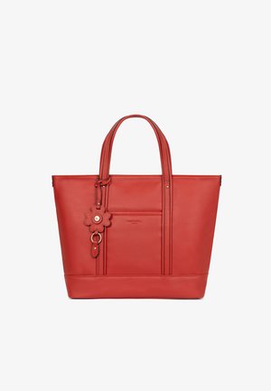 Sac cabas en cuir rouge avec deux poignées, une poche avant et un porte-clés en forme de fleur suspendu à une poignée.