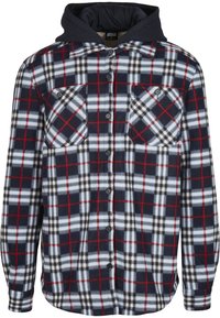 Camisa de franela con patrón de cuadros en navy, blanco y rojo; presenta mangas largas, dos bolsillos en el pecho y una capucha negra. Textura suave.