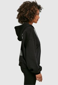 Merchcode WD - STRONG AS A  - Kapucni - black