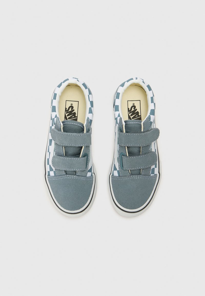 Blaue Leinenschuhe mit einem karrierten Muster, zwei Velcro-Riemen und einer weißen Gummisohle. Die Innenauskleidung ist cremefarben.