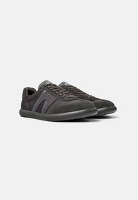 Dark gray athletic shoes featuring a mix of suede and breathable mesh, textured lace detailing, and a flexible rubber sole.